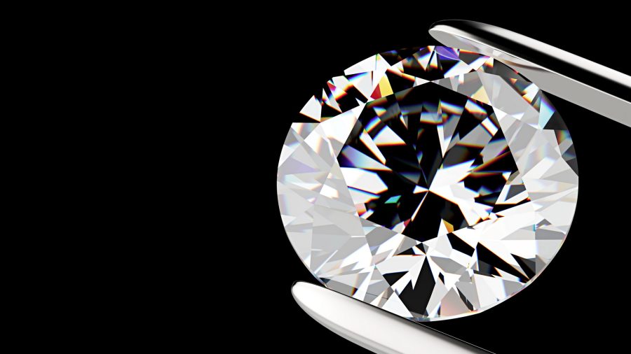 Diamond in the tweezers on a black background