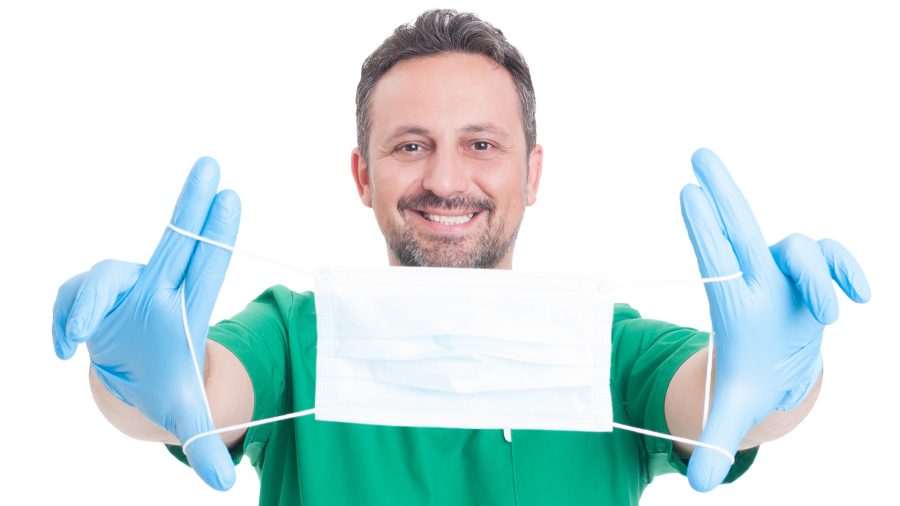 Doctor holding surgical or surgeon mask with text area or copy space on it