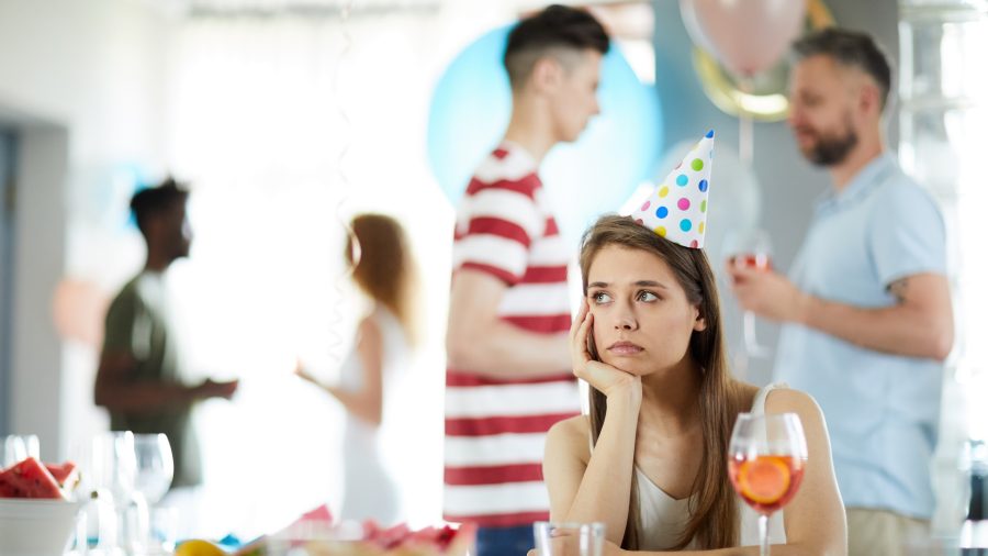 Portrait of sad young woman sitting alone at party, copy space